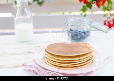Delish Frühstück mit frischem Obst bei der Gartenparty, aussen mit Blumen hinter und frischen Kräutern auf der Oberseite Stockfoto