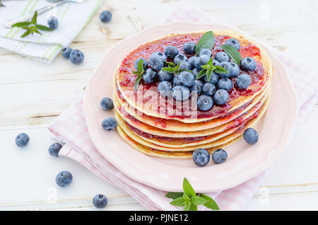 Delish Frühstück mit frischem Obst bei der Gartenparty, aussen mit Blumen hinter und frischen Kräutern auf der Oberseite Stockfoto