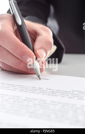 7/8-Ansicht von einem Geschäftsmann einen Vertrag unterzeichnen. Flache Fokus auf Signatur. Stockfoto