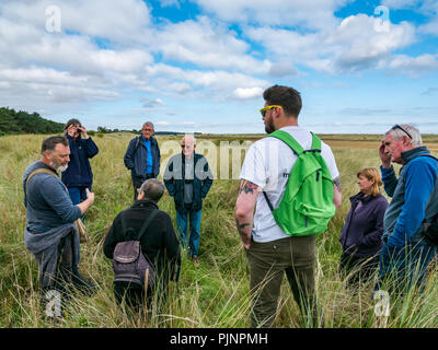 John Muir Country Park, Dunbar, East Lothian, Schottland, Großbritannien, 8. September 2018. Eine kleine Gruppe von Menschen genießen Sie einen Spaziergang und Gespräch von David Connelly von East Lothian Rat Archäologie Service Prüfung Nachweis der Weltkrieg defensive Positionen während East Lothian Archäologie und lokale Geschichte vierzehn Tage im September findet jedes Jahr statt und ist Teil der jährlichen Schottischen Archäologie Monat. Übersicht überwachsen Beweis des Ersten Weltkriegs Gräben in der Düne Bank Stockfoto