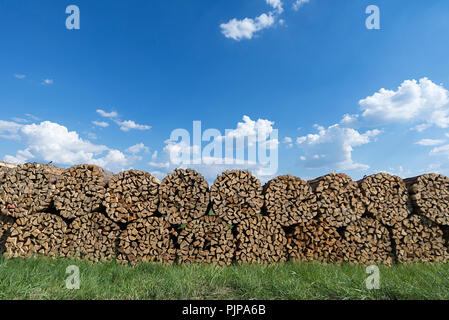 Runde gebündelt Brennholz gestapelt, blauer Himmel, Deutschland Stockfoto