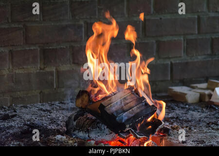 Glühende Holz Brennen log in der klaren Brand Nahaufnahme. Atmosphärischen Hintergrund mit Flamme der Lagerfeuer. Schönes Bild von der Brand von innen mit c Stockfoto