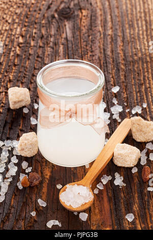 Tibi Kristall, tibicos, Zucker, Kefir, Körner in Glas Glas mit Zucker und trockene Frucht auf hölzernen Tisch. Stockfoto