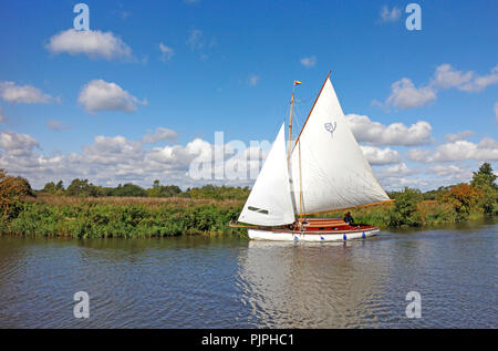 Eine Yacht in vollen Segeln auf dem Fluss Ameise auf den Norfolk Broads vorbei wie Hügel bei Ludham, Norfolk, England, Vereinigtes Königreich, Europa. Stockfoto