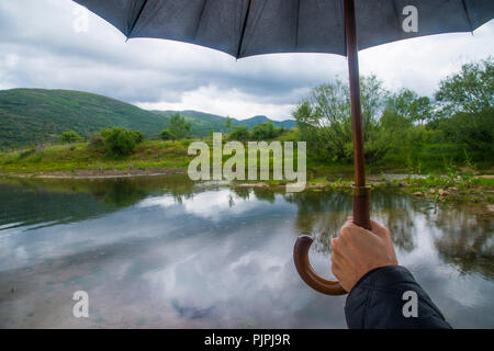 Der Mann hält un-Regenschirm in Pinilla Behälter. Lozoya, Provinz Madrid, Spanien. Stockfoto