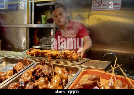 Peking, China - 1. Juni 2018: Koch in seinem roten Uniform kochen traditionelles Chinesisch Essen auf Snack Street an der Stadt Beijing in China Stockfoto