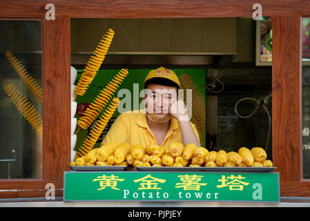 Peking, China - 6. Juni 2018: Küchenchef in einem gelben Uniform, die traditionelles Chinesisch Essen auf einem blumenmärkte in Peking in China. Stockfoto