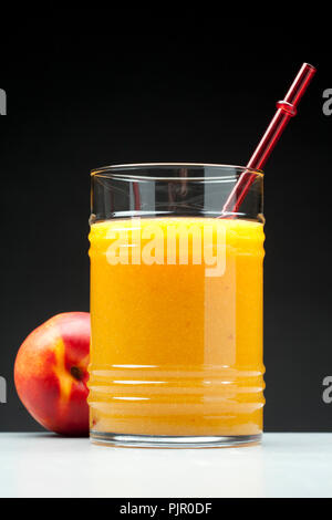 Pfirsich Saft im Glas auf schwarzem Hintergrund Stockfoto