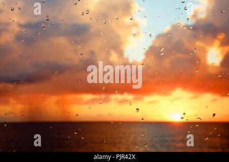 Sonnenuntergang mit hohen Wolken durch ein Regentropfen fallen Fenster gesehen. Stockfoto