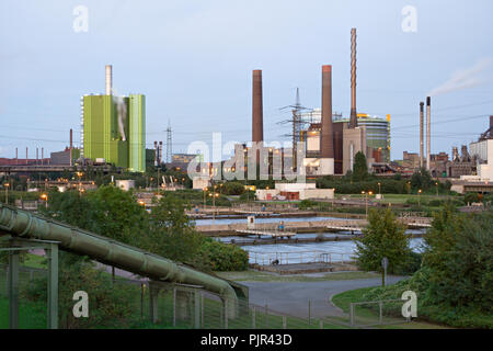 Blick über eine Pipeline und eine Kläranlage zu vielen industriellen Gebäuden. Stockfoto