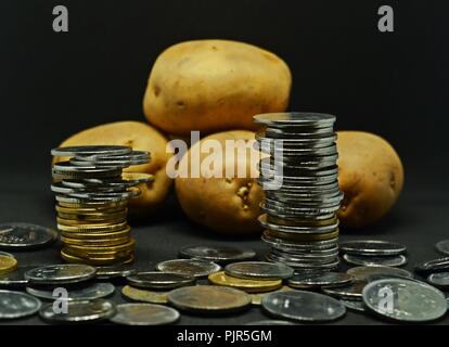 Angehäuft Kartoffeln mit viel indische Rupie Münzen Stockfoto