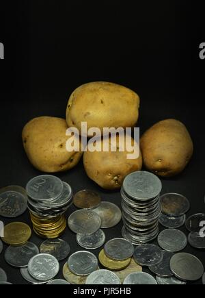 Angehäuft Kartoffeln mit viel indische Rupie Münzen Stockfoto