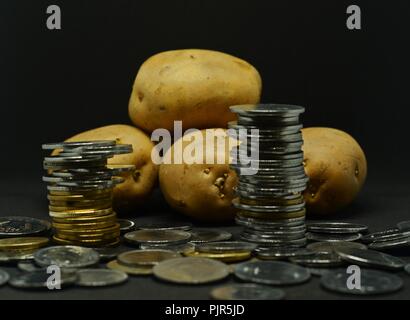 Angehäuft Kartoffeln mit viel indische Rupie Münzen Stockfoto