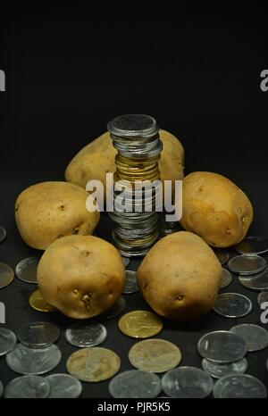 Angehäuft Kartoffeln mit viel indische Rupie Münzen Stockfoto