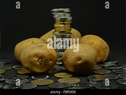 Angehäuft Kartoffeln mit viel indische Rupie Münzen Stockfoto