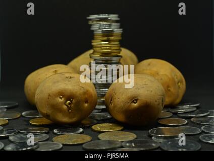 Angehäuft Kartoffeln mit viel indische Rupie Münzen Stockfoto