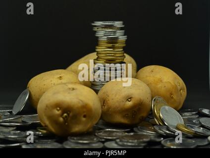 Angehäuft Kartoffeln mit viel indische Rupie Münzen Stockfoto