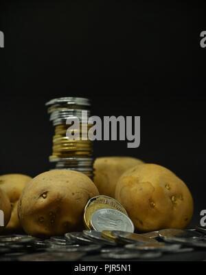 Angehäuft Kartoffeln mit viel indische Rupie Münzen Stockfoto