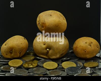 Angehäuft Kartoffeln mit viel indische Rupie Münzen Stockfoto