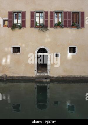 Windows und Torbogen führt zu Fluss in Annecy, Frankreich Stockfoto