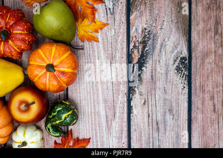 Bunte Herbst Holz- Hintergrund mit Maple Leaves, Kürbisse, Kürbisse und andere saisonale Herbst Gemüse. Extra copyspace, nützlich für die Kopfzeilen Stockfoto
