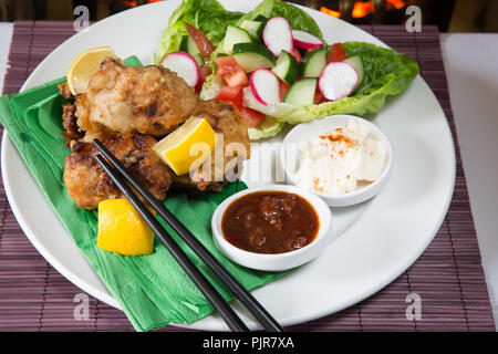 Ein tellergericht Huhn Karaage mit roter Chili bean Dip und Paprika Joghurt serviert mit Frischer gemischter Salat Stockfoto