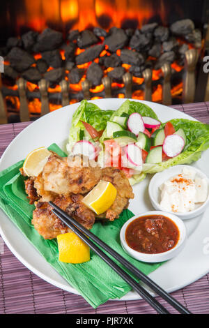 Ein tellergericht Huhn Karaage mit roter Chili bean Dip und Paprika Joghurt serviert mit Frischer gemischter Salat Stockfoto