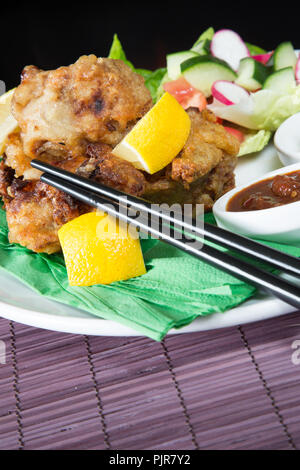 Ein tellergericht Huhn Karaage mit roter Chili bean Dip und Paprika Joghurt serviert mit Frischer gemischter Salat Stockfoto