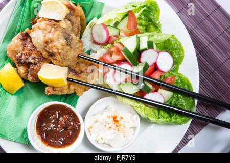 Ein tellergericht Huhn Karaage mit roter Chili bean Dip und Paprika Joghurt serviert mit Frischer gemischter Salat Stockfoto