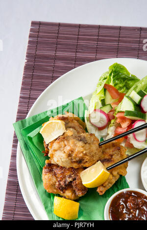 Ein tellergericht Huhn Karaage mit roter Chili bean Dip und Paprika Joghurt serviert mit Frischer gemischter Salat Stockfoto