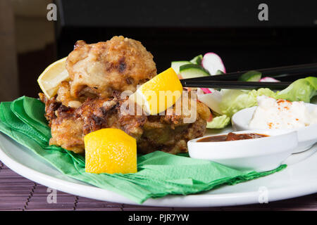 Ein tellergericht Huhn Karaage mit roter Chili bean Dip und Paprika Joghurt serviert mit Frischer gemischter Salat Stockfoto