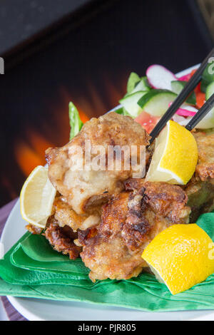 Ein tellergericht Huhn Karaage mit roter Chili bean Dip und Paprika Joghurt serviert mit Frischer gemischter Salat Stockfoto