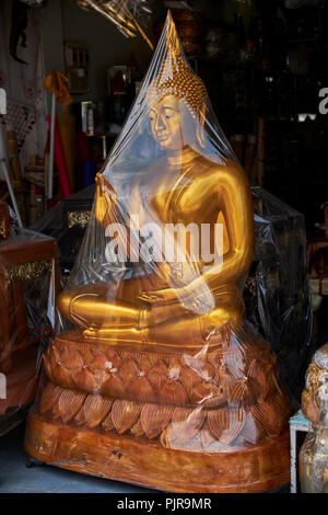 Plastik eingewickelt Golden Buddha für Verkauf in einem Thailand Shop. Stockfoto