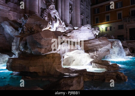 Nacht Szene am Trevibrunnen - Fontana di Trevi in Rom, einer der berühmtesten Wahrzeichen. Nahaufnahme des Wasser fließt durch den Felsen Stockfoto