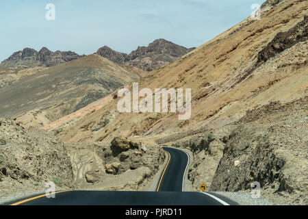 Straße durch Artist's Fahrt zum Artist's Palette im Death Valley National Park mit farbenfrohen Felsformationen in einem Schwemmkegel in den Schwarzen Mounta Stockfoto