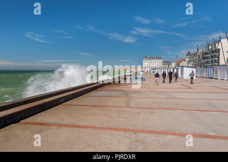 Wimereux, Frankreich - 16. Juni 2018: die Menschen zu Fuß direkt an der Uferpromenade als Wellen schlagen die Sea Wall. Stockfoto
