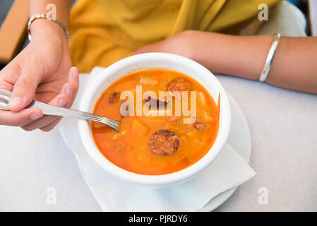 Weibliche essen Ungarische Suppe mit Wurst in einem Restaurant Stockfoto