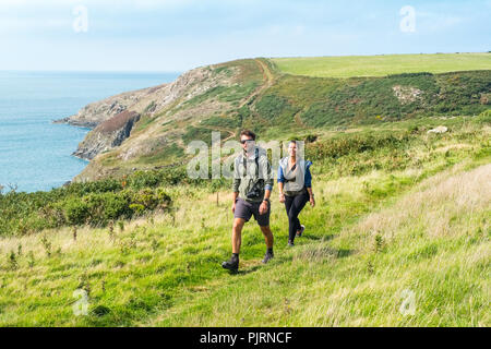 Pembrokeshire Coast National Park, Wales, UK. Paar in den 20er Jahren gehen auf die Küste in der Nähe von Strumbles Kopf Stockfoto