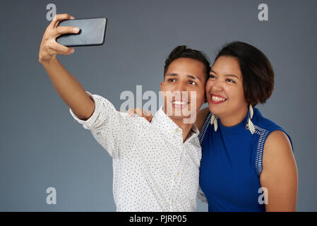 Junges Paar nehmen selfie auf Grau studio Hintergrund isoliert Stockfoto