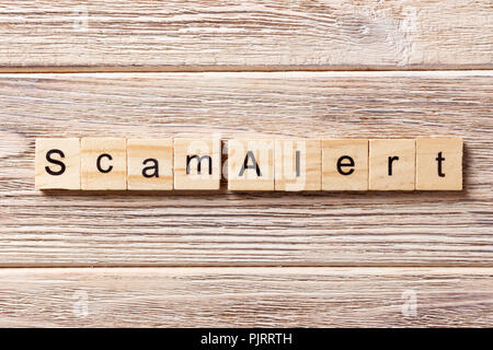 Scam alert Wort auf Holz Block geschrieben. Scam alert Text auf Tisch, Konzept. Stockfoto