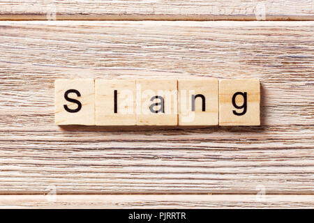 Slang Word auf Holz Block geschrieben. slang Text auf Tisch, Konzept. Stockfoto