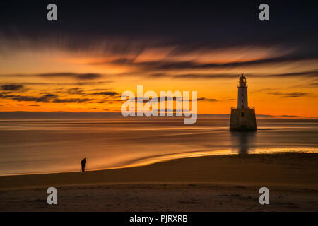 Fotograf bei Rattray Head Lighthouse in Sunrise Licht, Ostküste Schottlands Stockfoto