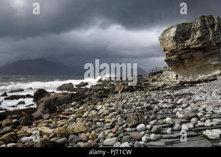 Touristen auf Felsen von elgol Strand von Port na Cullaidh mit Red Cuillin Berge unter Wolken am Loch Scavaig Isle of Skye Schottland Großbritannien Stockfoto