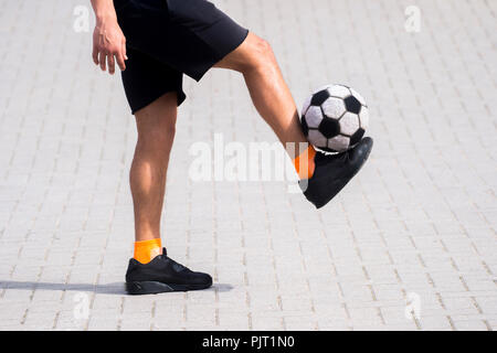 Seitenansicht des freestyle Soccer oder Futsal player juggling Ball mit seinen Beinen. Stockfoto