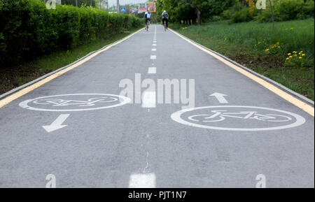 Gemalten Schildern auf Asphalt für Fahrrad gewidmet. Ein separater Fahrradweg in der Stadt, Radfahrer auf dem Radweg. Stockfoto