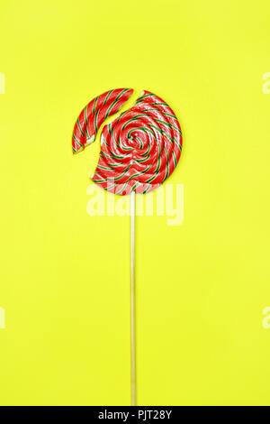 Gebrochene lollipop auf gelbem Hintergrund, Ansicht von oben Stockfoto