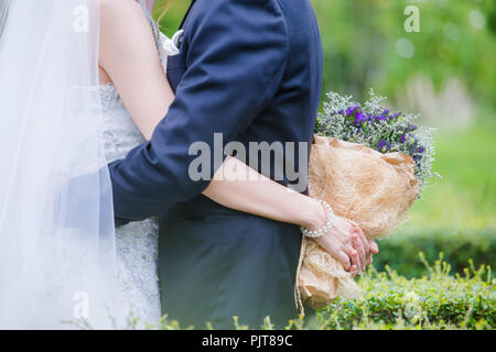 Brautpaar mit einem Strauß Blumen ist das Symbol der Liebe und der Ehe. Stockfoto