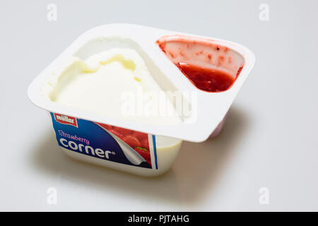 Single-use Kunststoffbehälter von Müller Obst Ecke Erdbeere Kompott mit Joghurt geöffnet und auf einen weißen Hintergrund mit Schatten isoliert. England Großbritannien Stockfoto