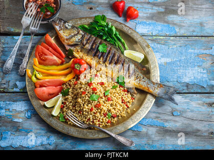 Den gegrillten Wolfsbarsch auf coper Platte, im marokkanischen Stil, kopieren Raum Stockfoto