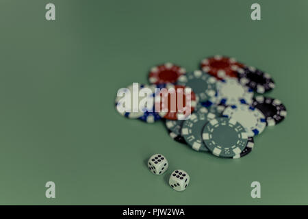 Würfel und farbigen Casino Chips auf einem schwarzen Hintergrund. Stockfoto